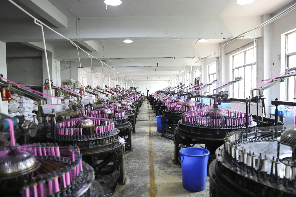 Spacious lace factory interior with various textile machinery and workers.