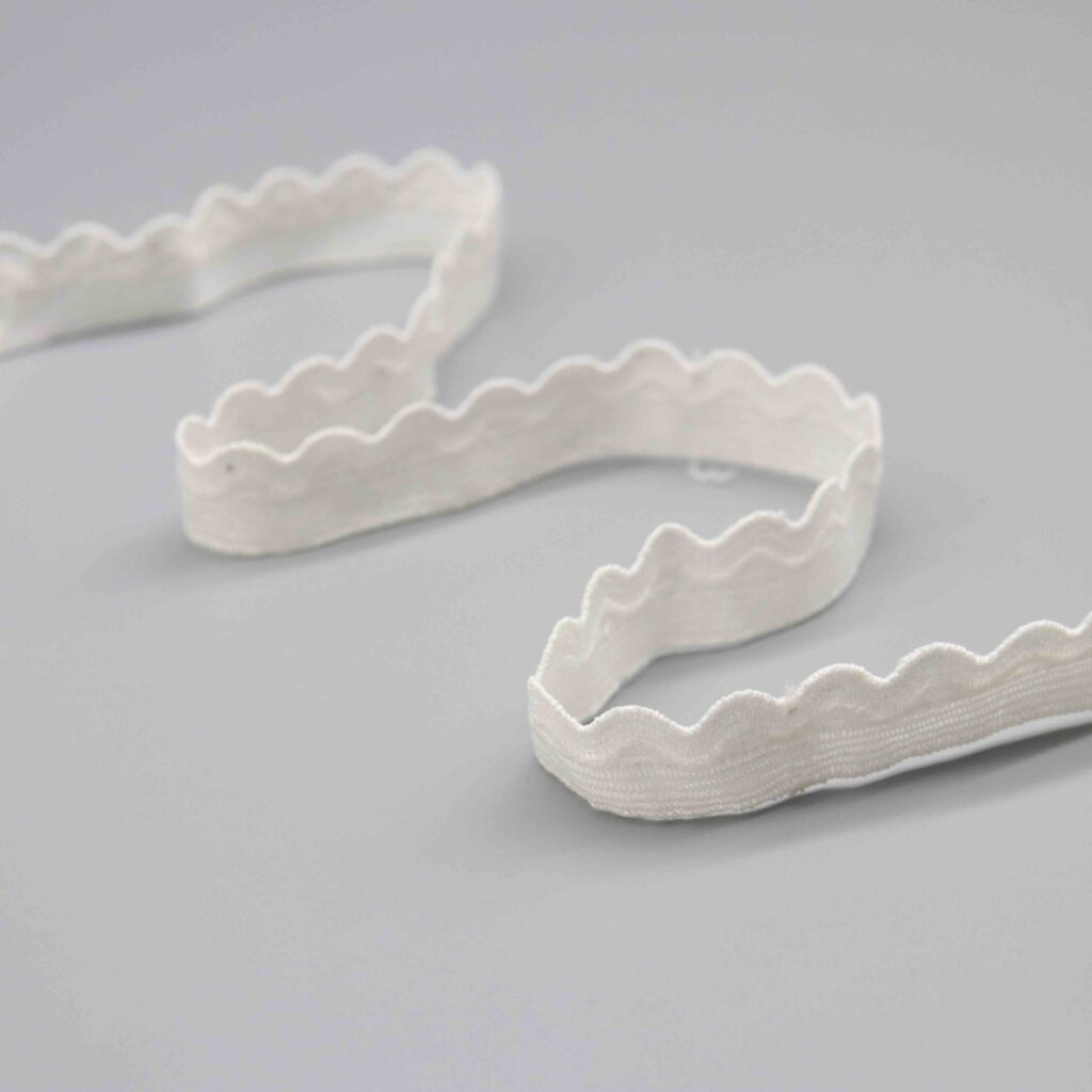 Detailed view of a narrow 2cm white polyester lace trim