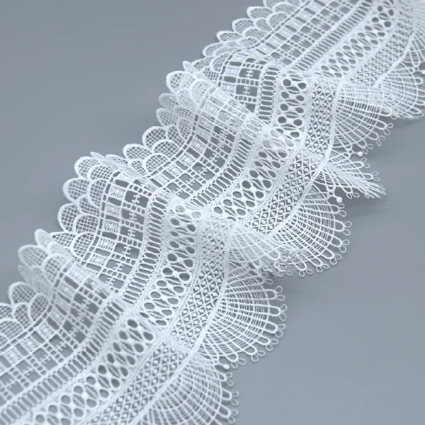 Delicate embroidered trimming lace made from water soluble material for luxurious garment accents.