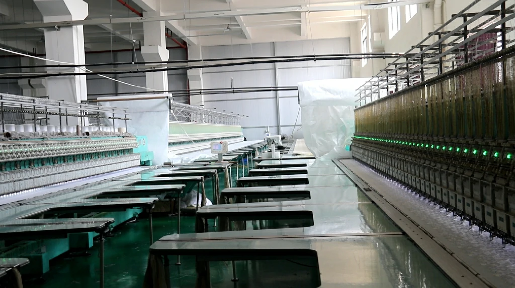 Wide-angle photo of a lace factory floor featuring rows of automated embroidery machines crafting delicate lace trims efficiently.