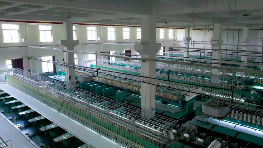 Modern lace production factory showcasing skilled technicians operating advanced embroidery machinery to manufacture premium quality lace.