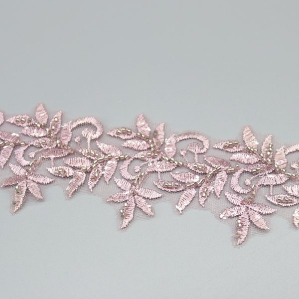 Sophisticated white and silver beaded lace trim, specially designed for bridal gowns and formal dresses. Alt Title: Lace Fabric Rolls Display
