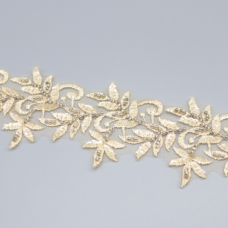 Detailed close-up showing fine embroidery stitches and beadwork, highlighting the quality of the handmade lace trim.