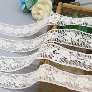 Elegant display of white French-style fancy lace trim alongside vintage crochet lace, highlighting distinct patterns for wedding table runners and chair sashes.