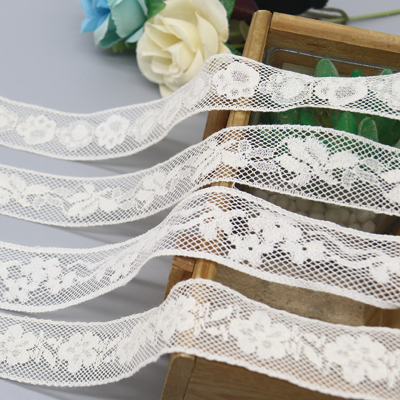 Elegant display of white French-style fancy lace trim alongside vintage crochet lace, highlighting distinct patterns for wedding table runners and chair sashes.