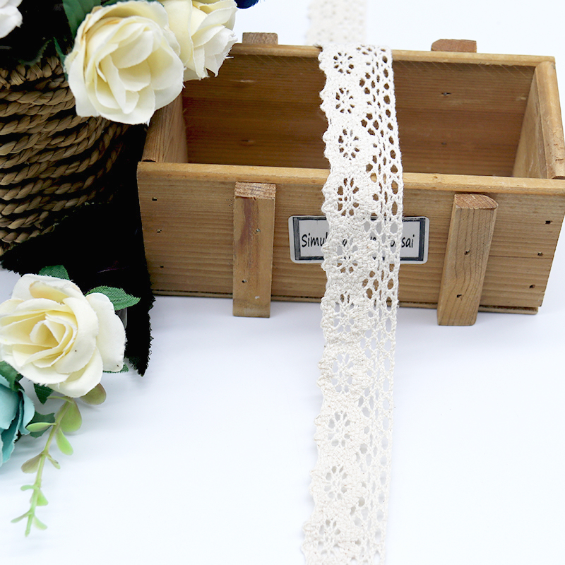 Close-up of exquisite cotton thread lace trim featuring delicate floral embroidery, perfect for couture fashion and elegant garment accents.