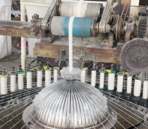 Wide view of a cotton thread lace manufacturing facility with skilled workers and advanced equipment handling large-scale lace production.