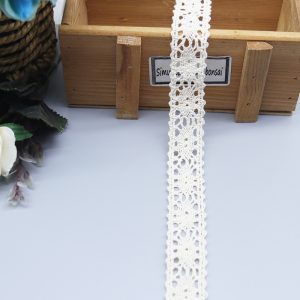 Close-up of soft cotton thread lace trim featuring an elegant floral pattern, ideal for enhancing fashion accessories and garments.