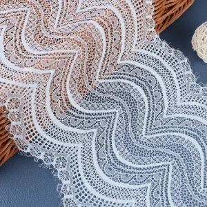 White vintage-style lace trim with delicate texture, designed for bridal gowns and special occasion dresses.
