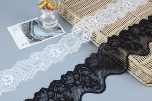 Side-by-side arrangement of white and black crocheted lace with bead accents and classic embroidery lace trim, designed for statement garment embellishments.