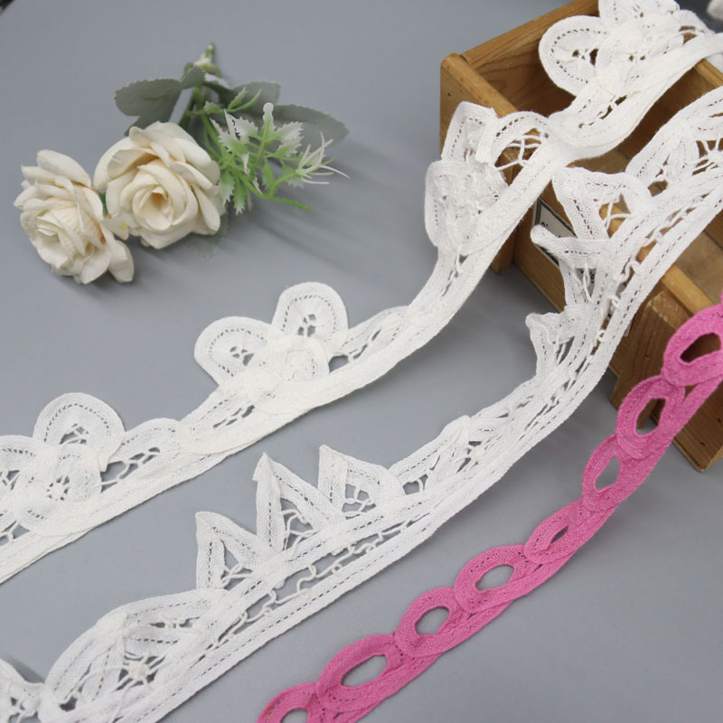 Close-up of pure cotton embroidered eyelet lace trim featuring a durable scalloped border, ideal for garment hems and decorative accents.