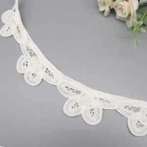 Detailed shot of embroidered pure cotton eyelet border lace showing floral motifs and sturdy edging for long-lasting trim use.