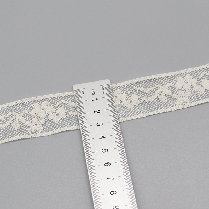 White fancy French lace trim and classic crochet lace used to decorate wedding tables, offering contrasting textures for luxury event settings.