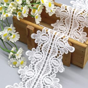 Close‑up appliqué pieces showing clean negative spaces on water soluble lace and dense texture on chemical lace.