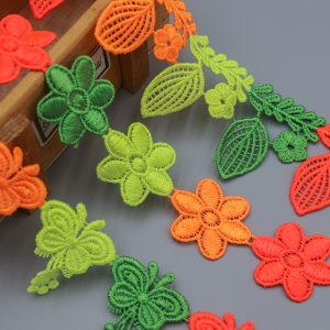 Brightly colored water soluble lace trim featuring embroidered flowers, leaves, and butterfly designs, ideal for creative garment and accessory decoration.