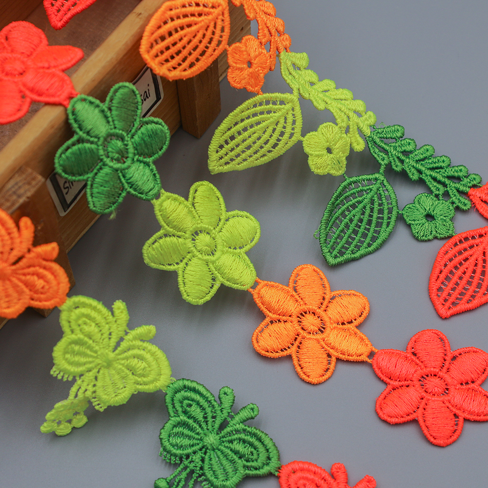 Brightly colored water soluble lace trim featuring embroidered flowers, leaves, and butterfly designs, ideal for creative garment and accessory decoration.