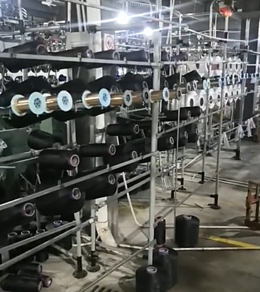  Interior of an OEM lace factory with parallel lines producing bias piping cord lace and grosgrain ribbon lace, technicians tuning machines to deliver multiple edge designs for fashion brands.