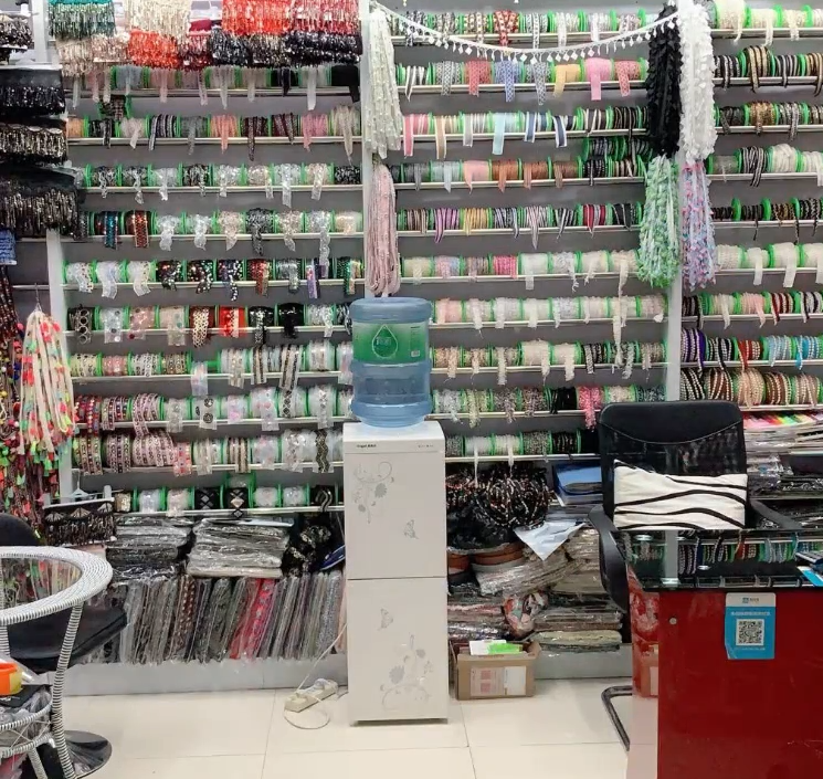 Modern lace factory floor with specialized equipment for piping‑cord insertion and grosgrain ribbon weaving, featuring rapid sampling, custom colors/widths, and quality control for OEM fashion orders.