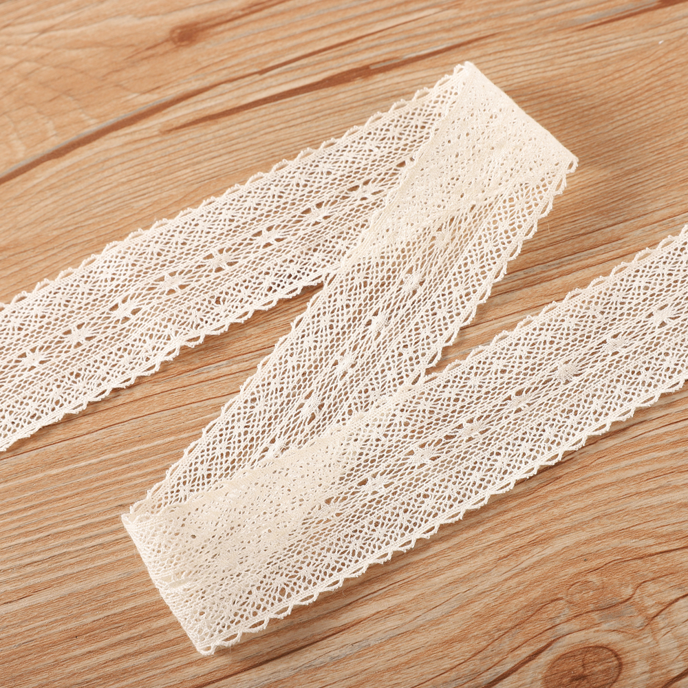 Wide shot of pure cotton beige lace featuring delicate embroidery set beside vibrant tassel cotton lace trims, ideal for creative ODM homeware accents.