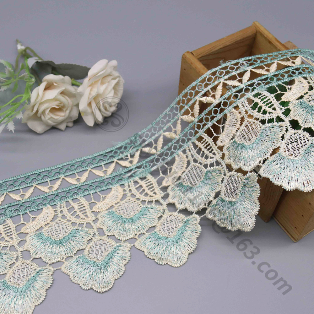 Close-up of delicate embroidery on water soluble lace next to crisp eyelet-patterned water soluble fabric, both ideal for premium fashion orders.