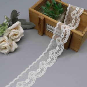 Close-up of elegant pure white scalloped floral lace trim ribbon on a soft nylon mesh base, with a straight edge for easy sewing and graceful wave arcs on the scalloped side adorned with plump embroidered flower motifs; lightweight and translucent, ideal for adding romantic details to dress hems and bridal accessories.