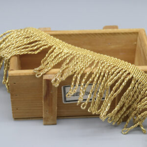 Top-down view of metallic gold fringe trim showing uniform strand length and wave pattern