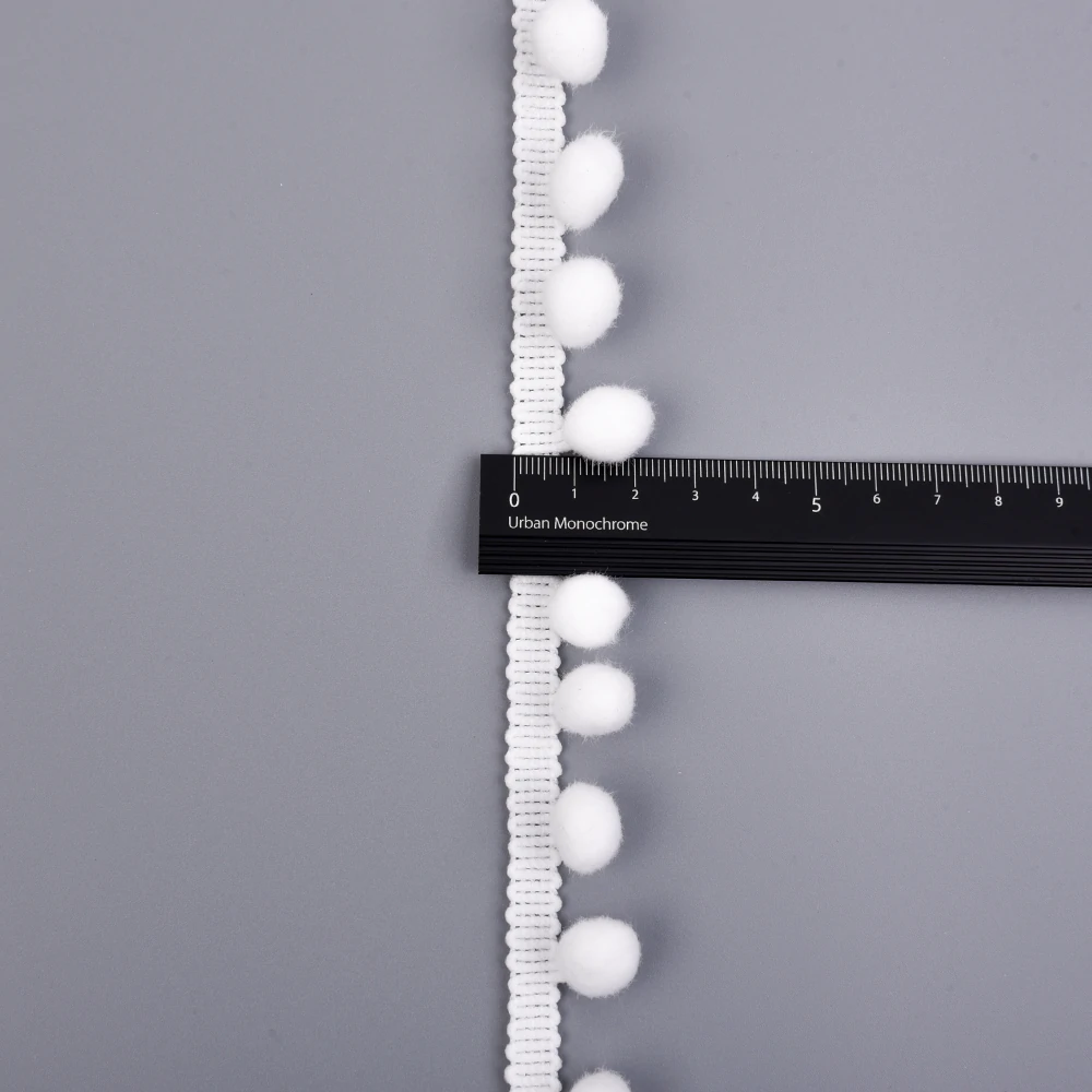 Detail of the scalloped crochet header band and pompom attachment points