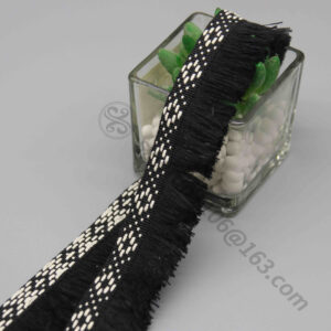 Front-facing shot of Diamond Lattice Polyester Fringe Lace Trim, showing the black and white geometric header pattern and brush fringe clearly.