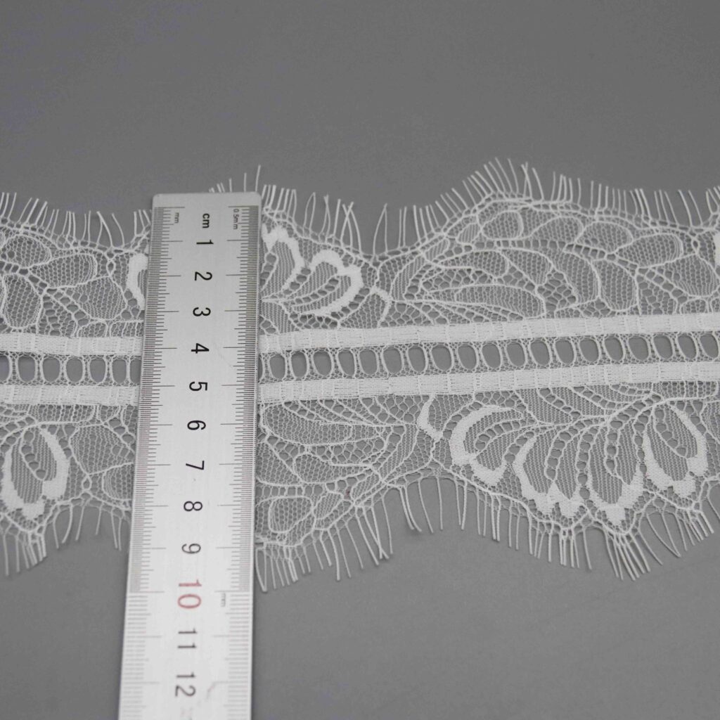 Angled shot capturing the lustrous nylon sheen and corded outline definition of the floral pattern