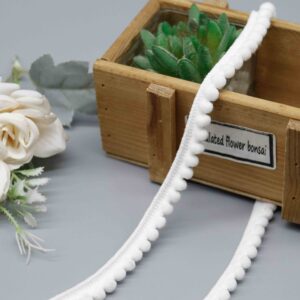 Front-facing shot of Mini Pompom Nylon Gimp Lace Trim, showing uniform white pompom balls and slim braided header clearly.