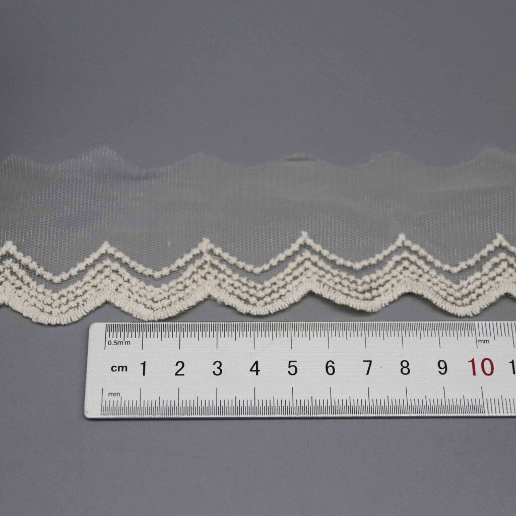 Ruler laid vertically across the lace trim showing the exact 5.5cm width measurement