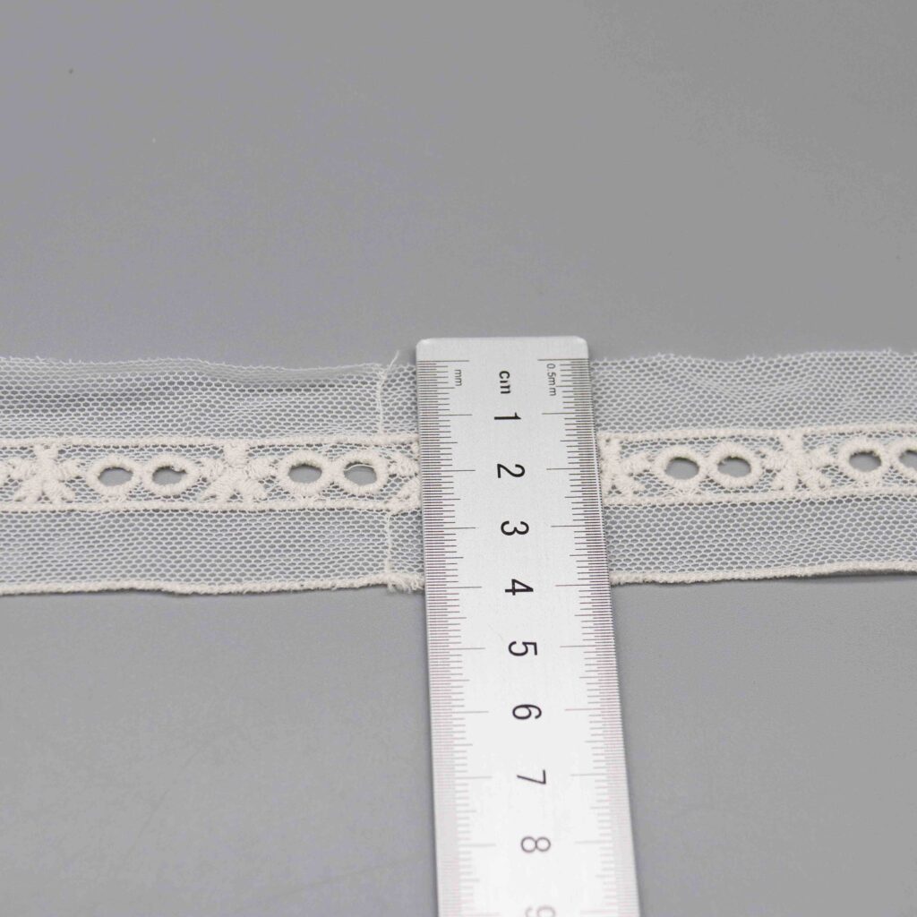 Ruler laid vertically across the lace trim showing the exact 4cm width measurement