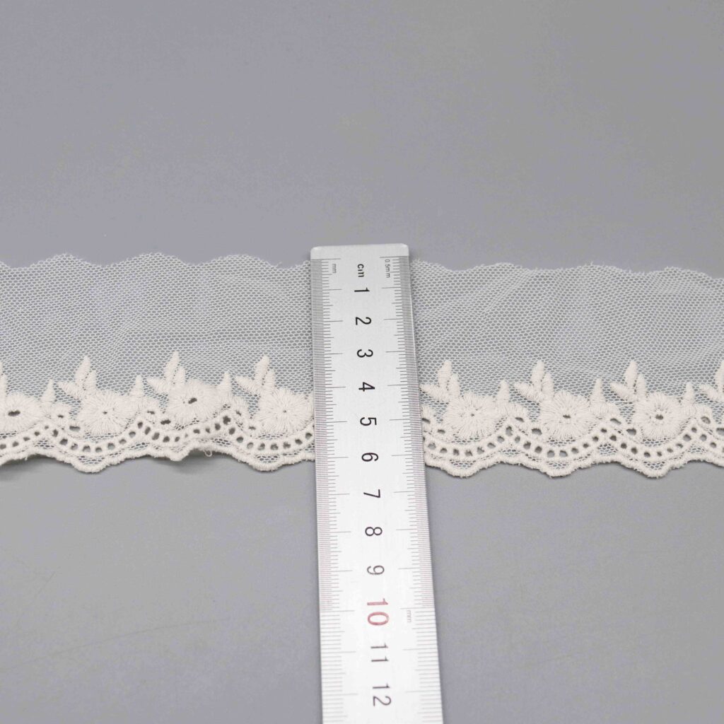 Ruler laid vertically across the lace trim showing the exact 6.5cm width measurement