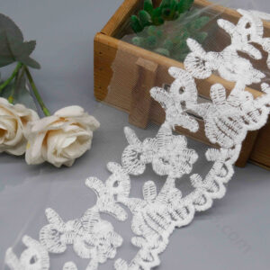 Front-facing shot showing scattered blossom embroidery on sheer tulle with loop scalloped border on white polyester lace.