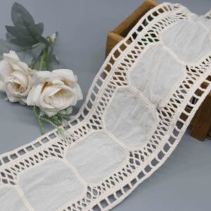 Front-facing shot showing geometric rectangular panels and twisted openwork borders on natural cotton laser embroidered lace.