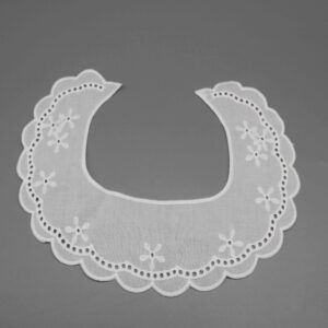 Front-facing shot showing classic curved collar shape with scattered floral embroidery on white cotton lawn.