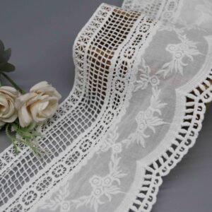 Front-facing shot showing multi-tiered lattice, medallion, and floral embroidery zones on white cotton water-soluble lace.