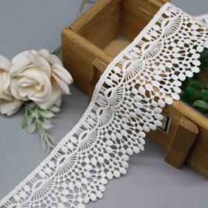 Front-facing shot showing the scalloped fan lace pattern and polyester texture clearly.