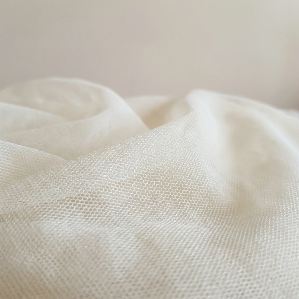 Soft rayon tulle fabric with delicate mesh pattern and natural drape