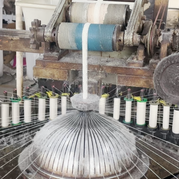 Wide view of a cotton thread lace manufacturing facility with skilled workers and advanced equipment handling large-scale lace production.
