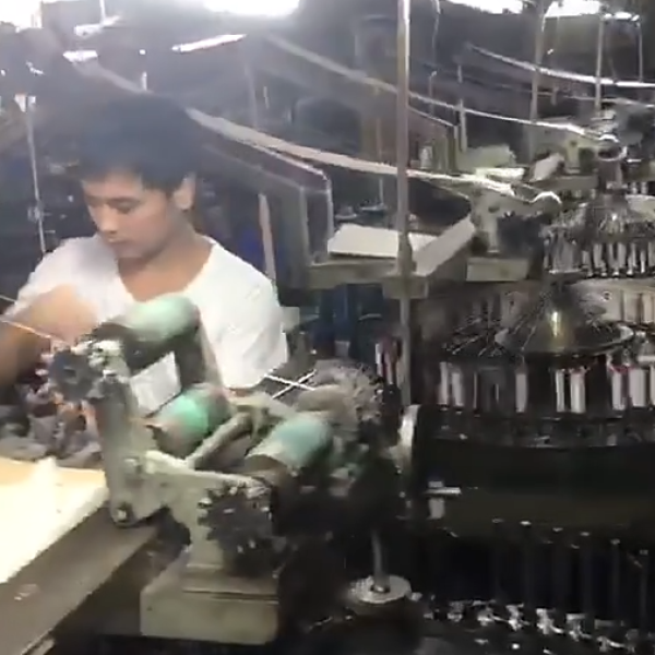 Wide-angle image of a cotton lace factory floor with automated embroidery machines creating durable border eyelet lace for wholesale orders.