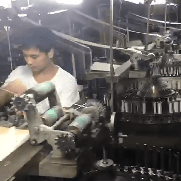 Wide-angle image of a cotton lace factory floor with automated embroidery machines creating durable border eyelet lace for wholesale orders.