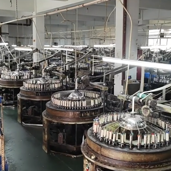 Overview of a large cotton thread lace production facility staffed by skilled workers and equipped with modern machinery.