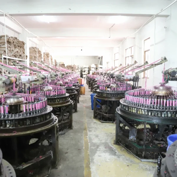 Modern lace loom operated by a technician in a busy textile plant.
