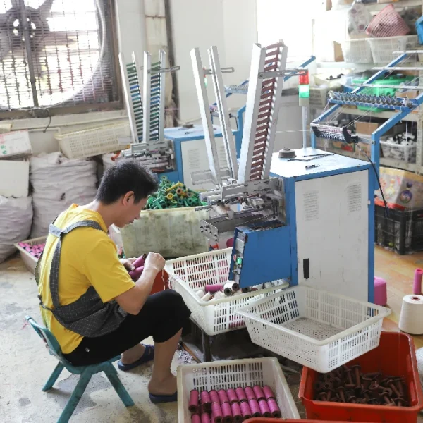 Factory worker operating lace manufacturing machine during production.